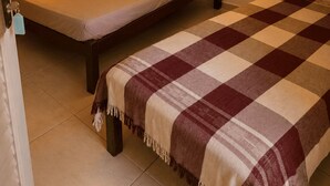 A single bed with a wooden headboard, a bedside lamp, a checkered blanket, and a window with curtains. -  Paz e Tranquilidade - Casa para 20 pessoas com 7 quarto (Capitólio)