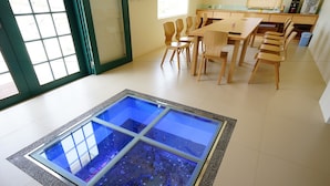 Uma área de jantar com mesa de vidro e cadeiras de madeira.