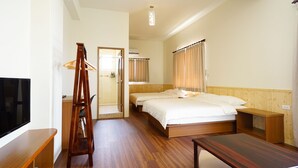 Quarto de hotel com cama de madeira, televisão, escrivaninha e uma escada.