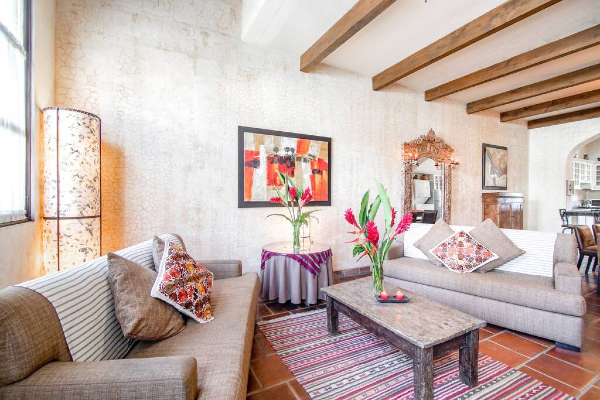 A living room with a sofa, coffee table, and decorative plants.