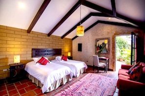 Quarto com duas camas, uma escrivaninha e uma cadeira.
