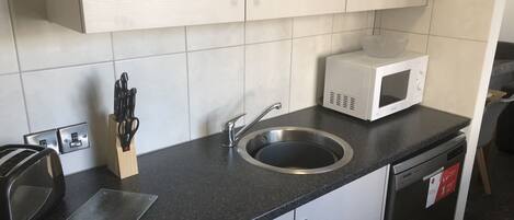 A modern kitchen with a stainless steel sink, a microwave, and a toaster.