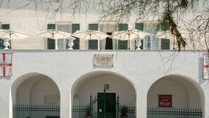 Un edificio con fachada blanca, contraventanas verdes y un cartel que dice "Villa Shelley ACSI".