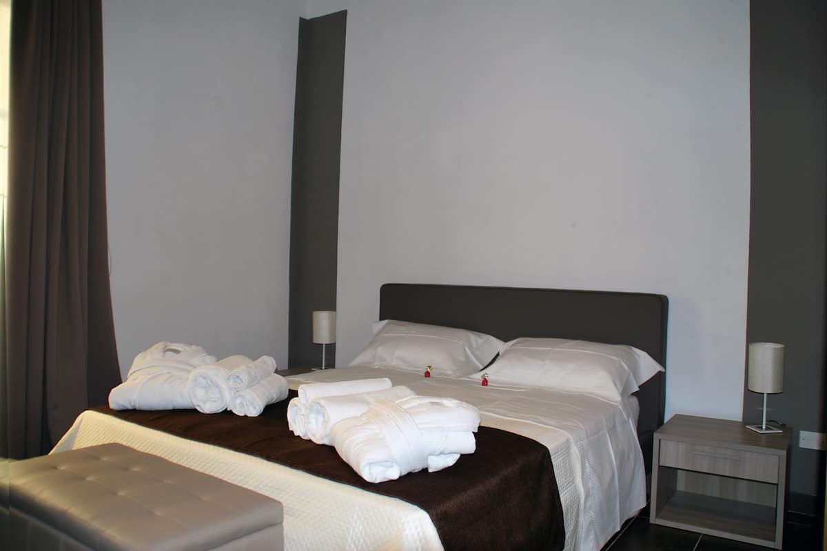 Une chambre d’hôtel avec un lit, une table de chevet et une lampe.