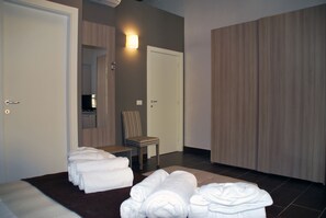 Ein Hotelzimmer mit einem Bett, einem Sessel und einem Stapel Handtücher.