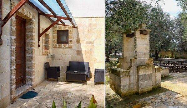 Un edificio de piedra con una puerta de madera, un ventanal pequeño y una banca.