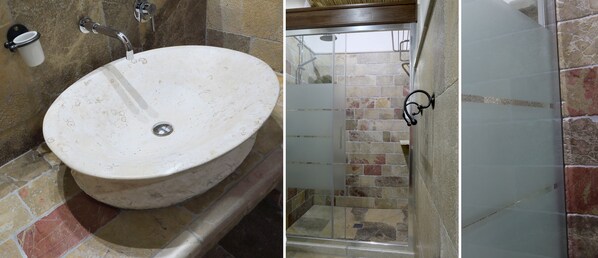 A bathroom with a round sink, a shower with a glass door, and a cup holder on the wall. - Masseria L'Uliveto (Otranto)