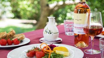 A table set with plates of food, a bottle of wine, and a pitcher.