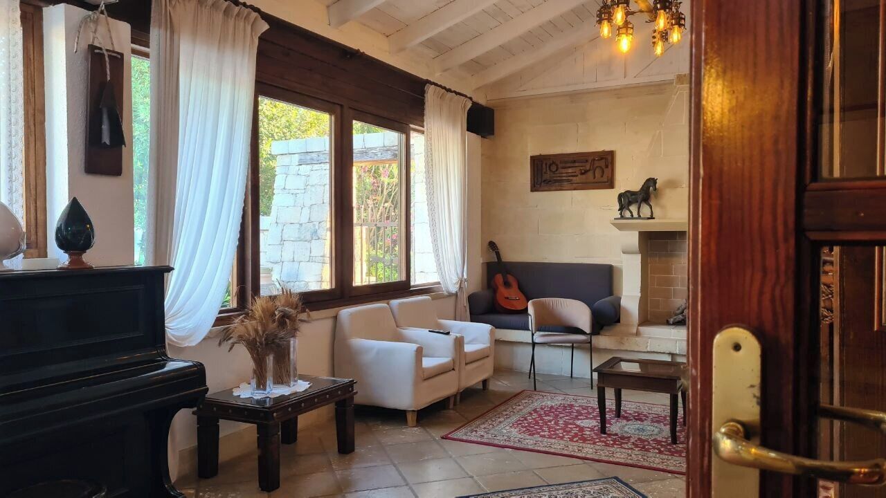 Una sala de estar con un piano, sofás, una guitarra y una chimenea.