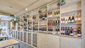 A wine cellar with shelves of wine bottles and glasses.