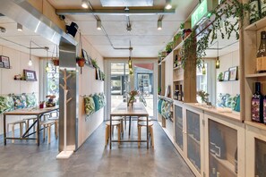 A modern interior with a central dining table, seating, and a view to the outside. - Stow Away Waterloo (London)
