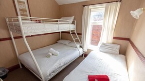 Dormitorio con literas, ventana y cortinas.