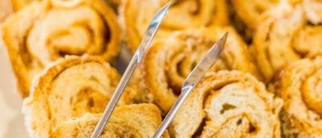 A plate of cinnamon rolls with a knife and fork.