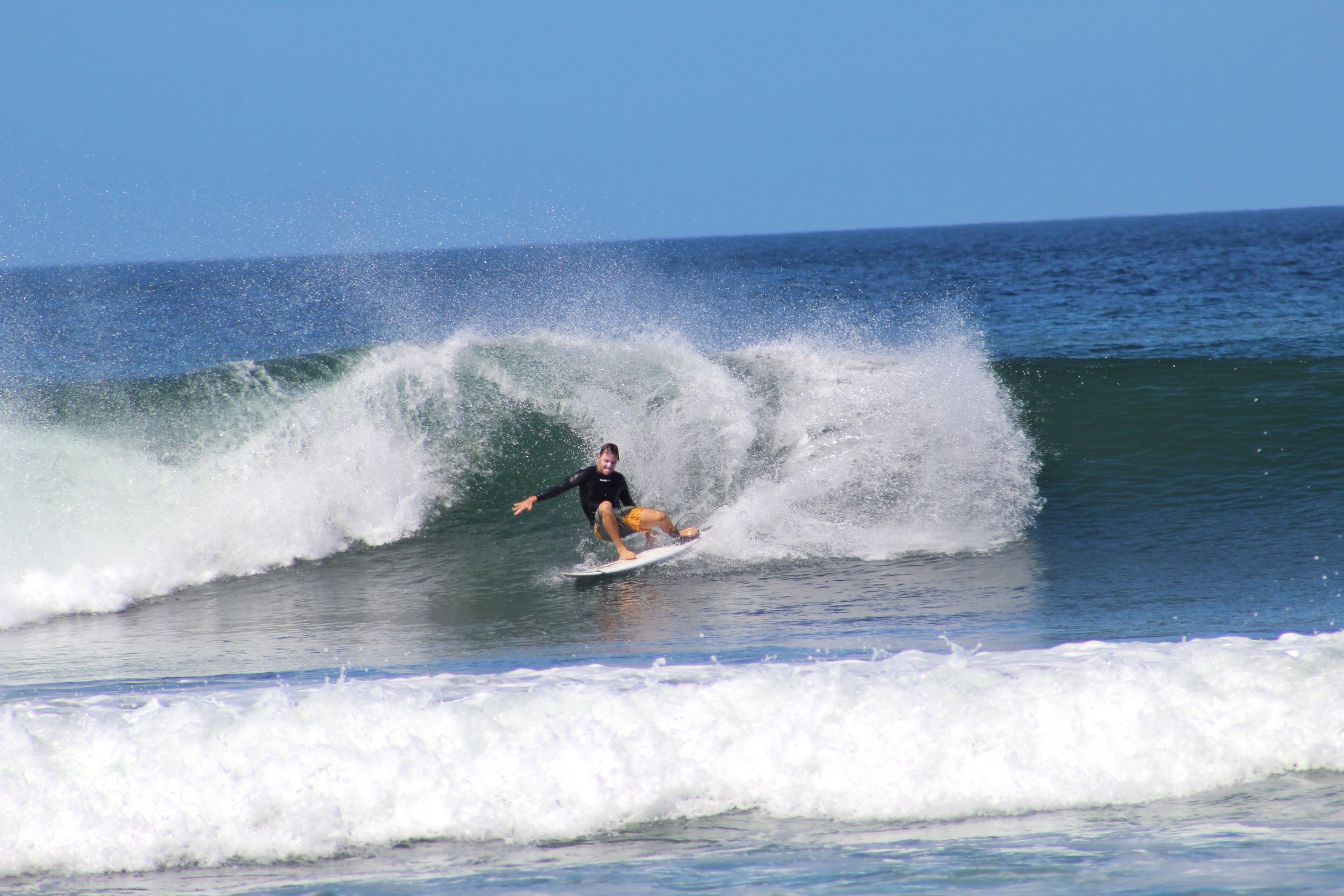A person surfing on a wave in the ocean.