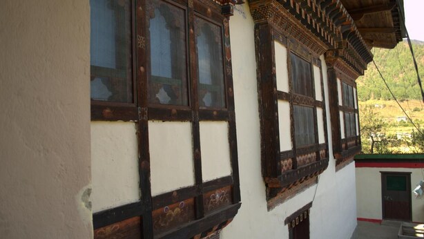 A traditional building with wooden window frames and white walls. - AMA's Village Lodge (Paro)
