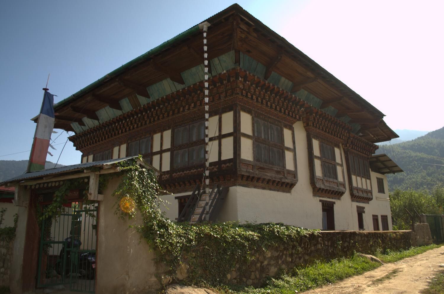 A traditional building with a steeply pitched roof, wooden beams, and a stone foundation.