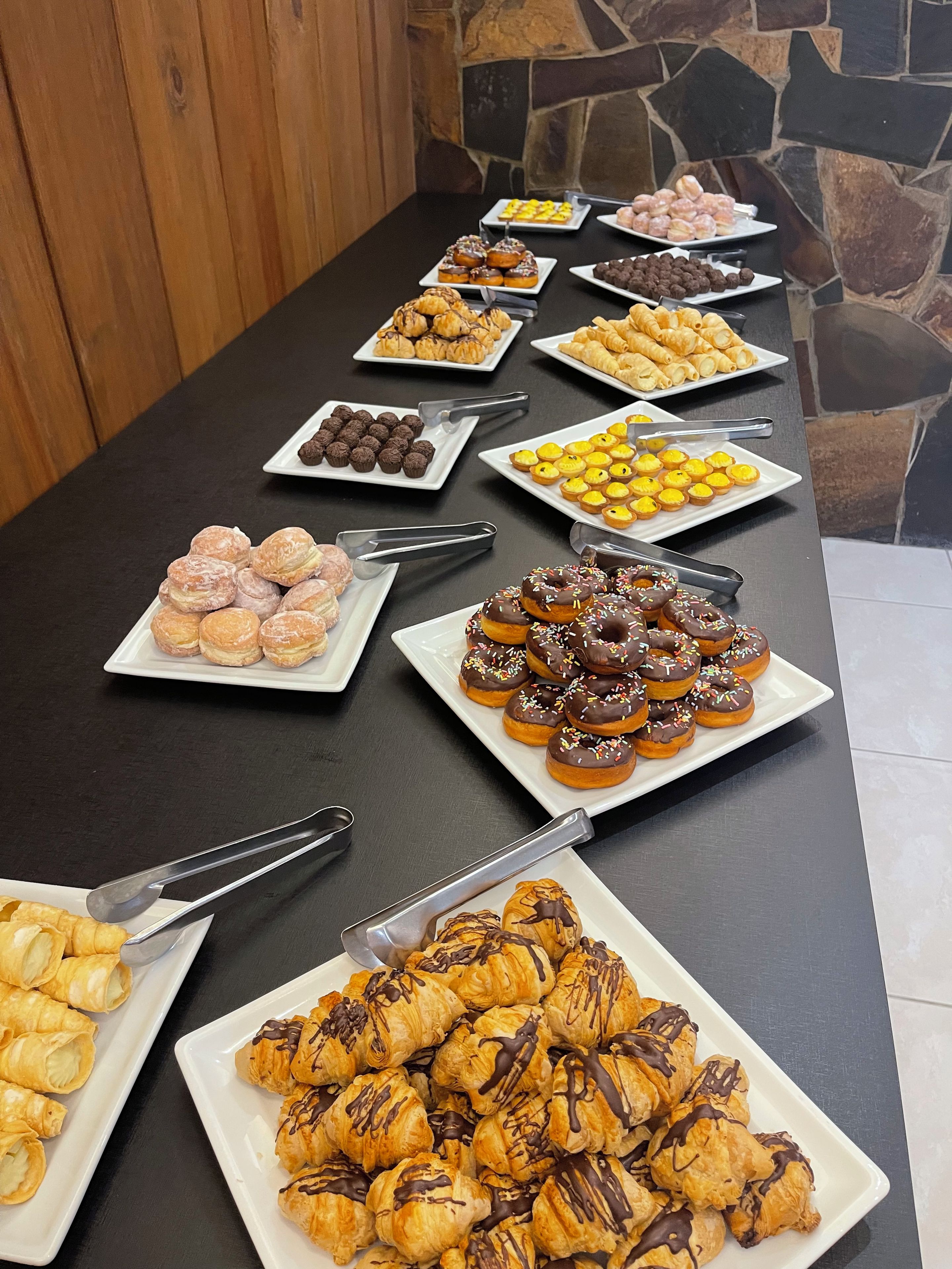 A buffet table with various pastries and desserts.