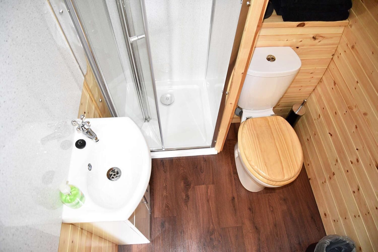 A compact bathroom with a shower, toilet, and sink.