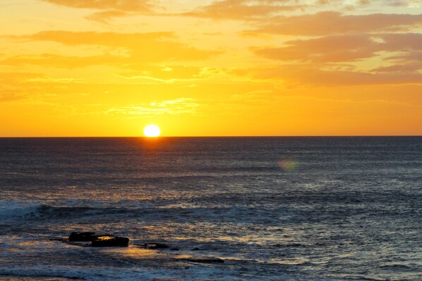 A sunset over the ocean with a rock in the foreground. - Suite Rivas 126 Gran Pacifica Resort (Villa El Carmen)