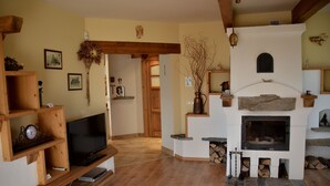 A cozy living room with a fireplace, wooden shelves, and a television. - Apartament Gorski z Panorama Tatr (Bialy Dunajec)