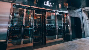 A modern building with a glass entrance and the number 810 displayed above. - Aliz Hotel Times Square (New York)