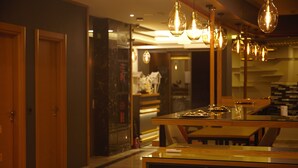 A modern kitchen with wooden cabinets, a central island, and pendant lighting. - Random Suit Otel (Istanbul)