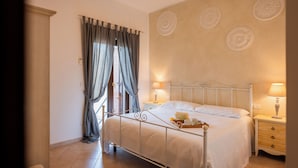A bedroom with a bed, bedside tables, and curtains. - Palazzo de Luca (Fasano)