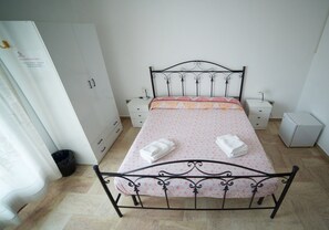 Cozy bedroom with a single bed, wardrobe, and bedside table.