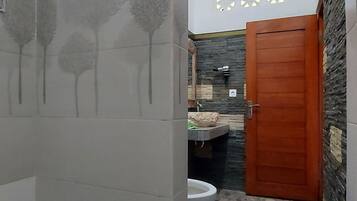 Un baño con inodoro, lavabo y zona de ducha.