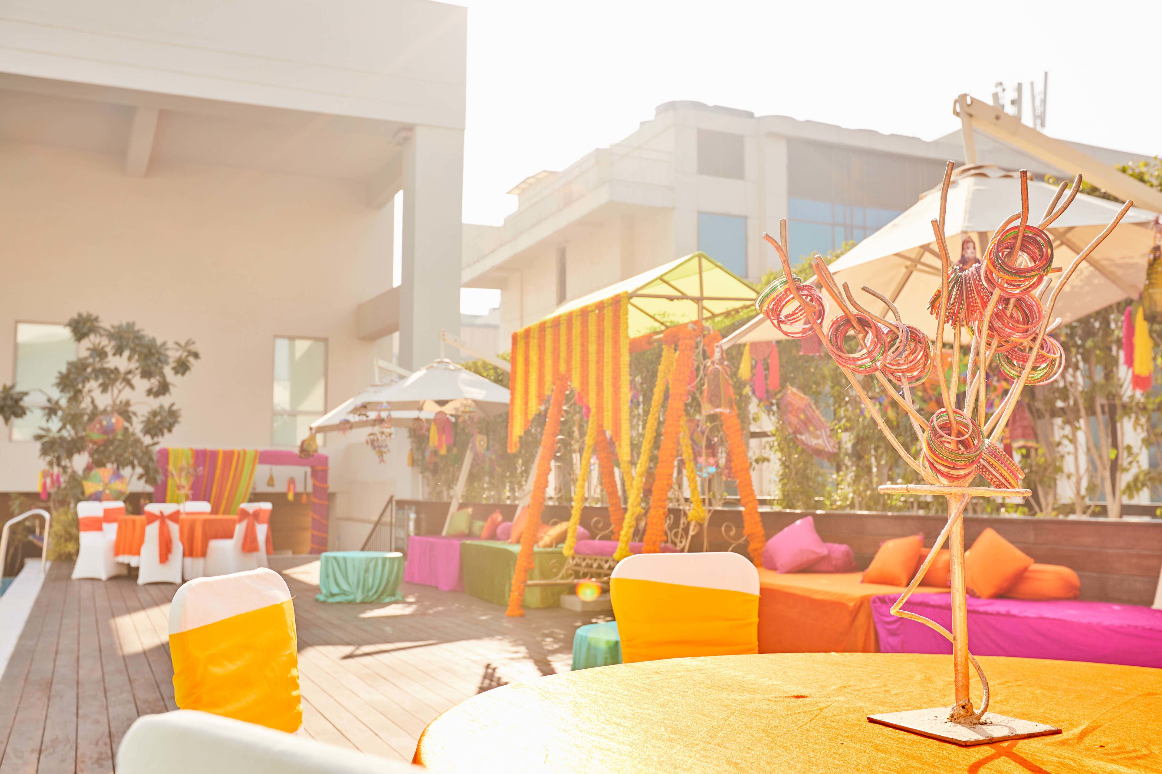 An outdoor seating area with colorful cushions and a decorative metal structure.