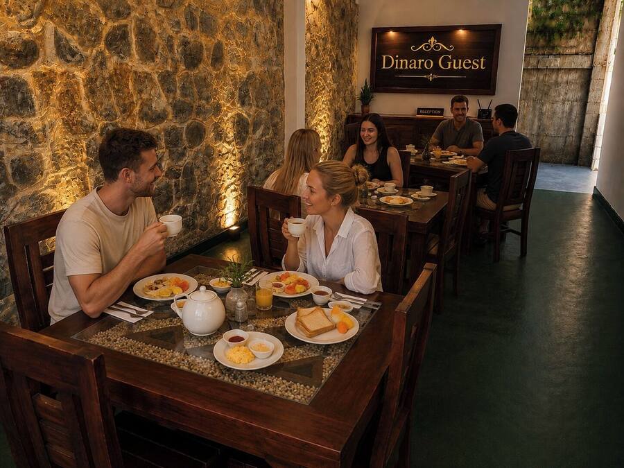 Interior de restaurante con paredes de piedra, mesas de madera y un cartel de recepción.