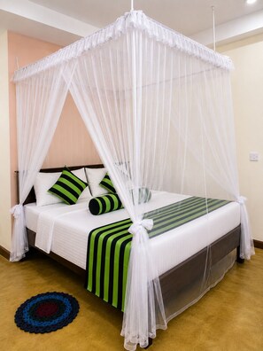 A bed with a canopy, pillows, and a striped bedspread. - Dinaro Guest (Ella)