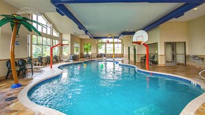An indoor swimming pool with clear water, a basketball hoop, and a palm tree decoration. - MainStay Suites Madison - Monona (Madison)