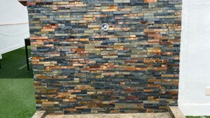 A stone wall with a built-in water feature and a stone bench. - Hostal Andalucia (Nerja)