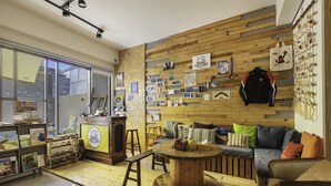 Un salon chaleureux avec un mur en bois, une table basse ronde et un canapé agrémenté de coussins colorés.