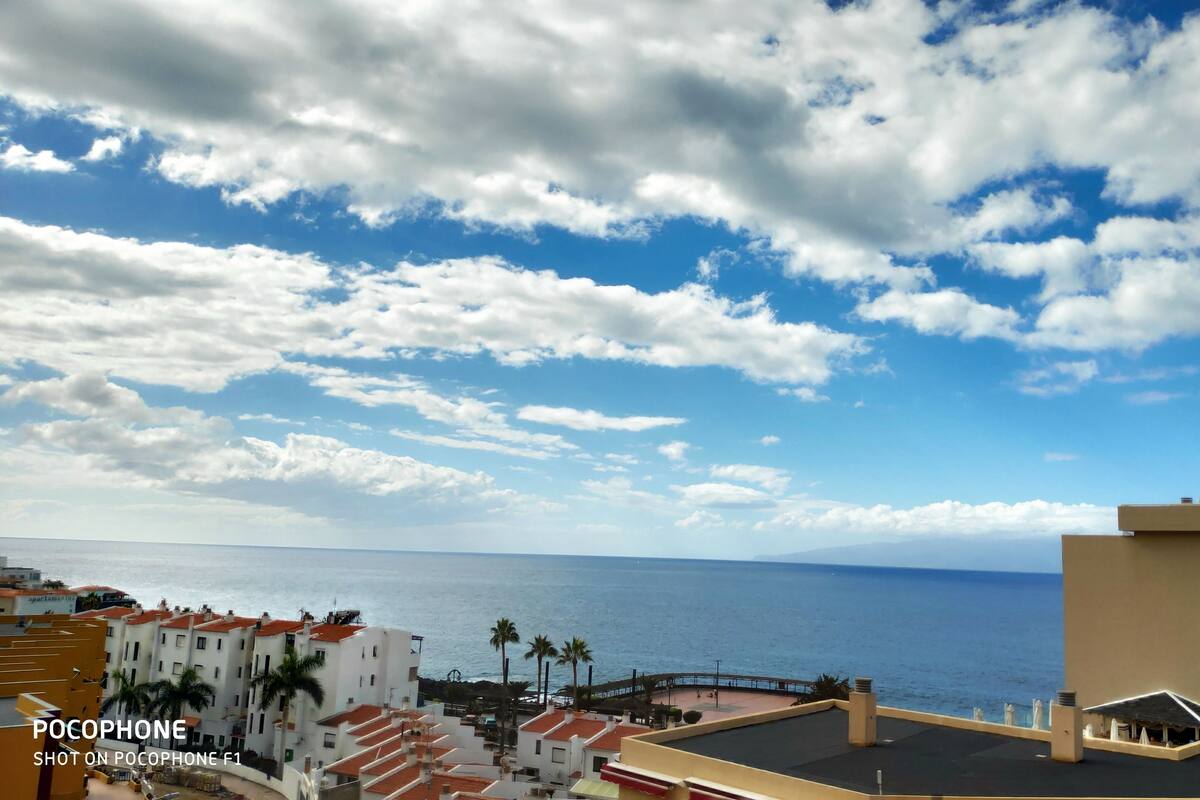 A coastal view with buildings, a clear sky, and the sea.