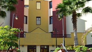 A set of outdoor stairs leading to a building with a yellow facade and red accents. - Olivia Sunbeach (Santiago del Teide)