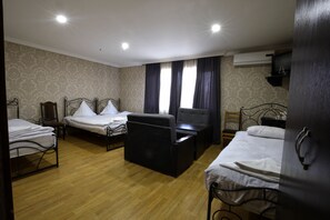 A hotel room with three beds, a desk, and a chair. - New Grand (Akhaltsikhe)