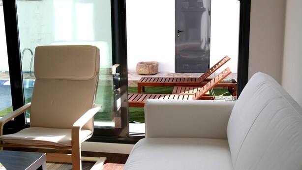 A modern living area with a sofa, a chair, and a table. - Casa Oretani (Picon)