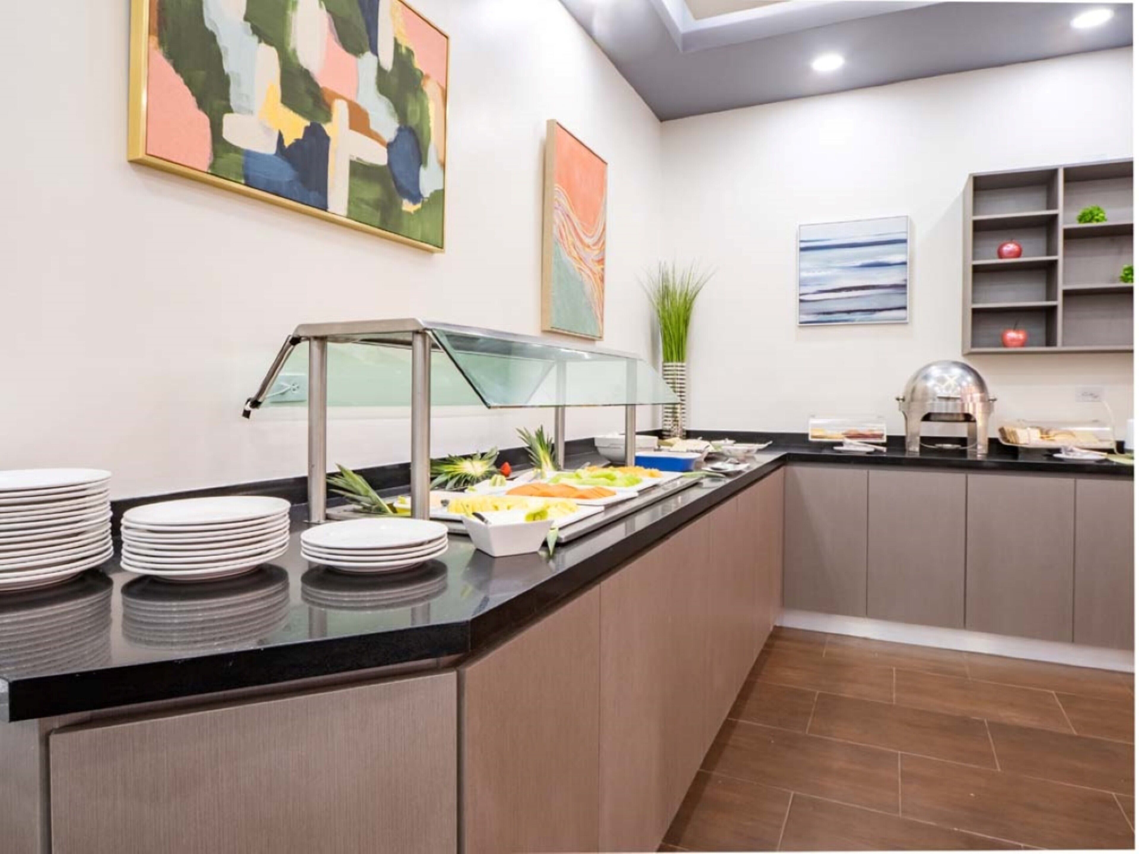 Zona de bufé con una vitrina de vidrio, platos y alimentos.