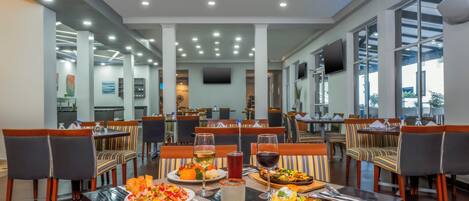 A restaurant with multiple dining tables, chairs, and a variety of dishes.
