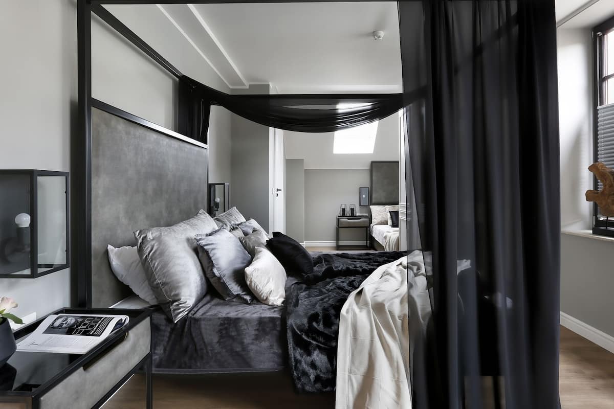 A modern bedroom with a bed, bedside table, and a nightstand.