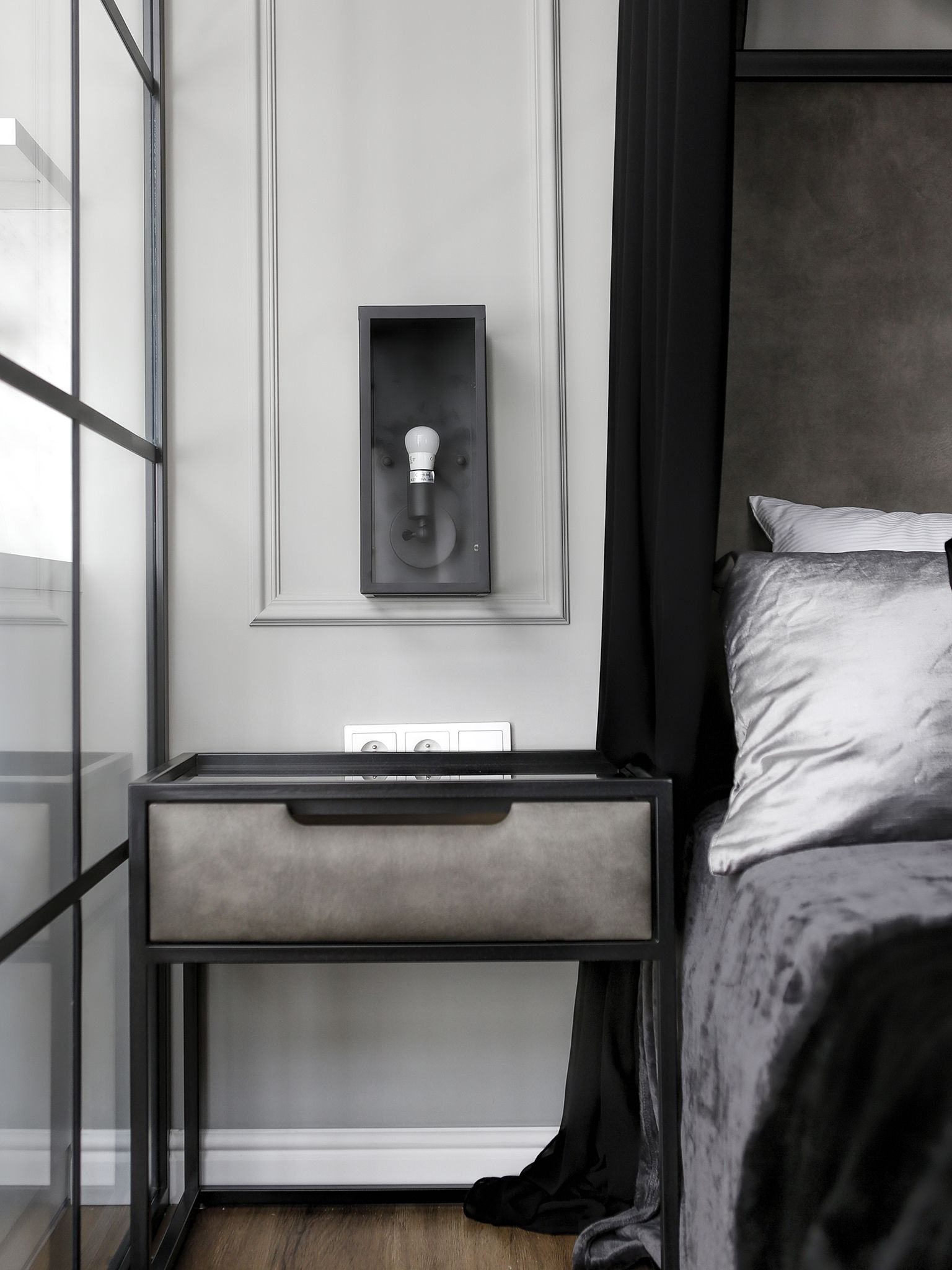 Una camera da letto moderna con un letto, un comodino con una lampada e una finestra vista.
