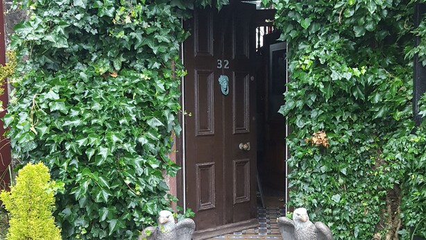 A door with the number 32, surrounded by dense green ivy. - Tower Guest House (Stornoway)