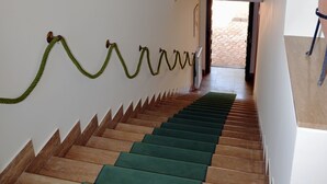 A staircase with alternating green and brown steps, white walls, and a decorative ceiling with geometric patterns. - Antica Villa di Bruto (Tivoli)