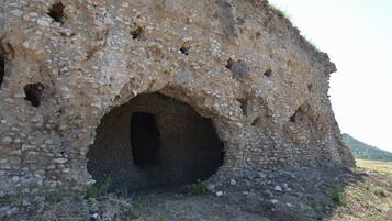 Una estructura de piedra con una abertura central grande y orificios más pequeños alrededor.