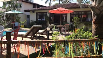 Una piscina al aire libre, sombrillas, sillones reclinables de piscina