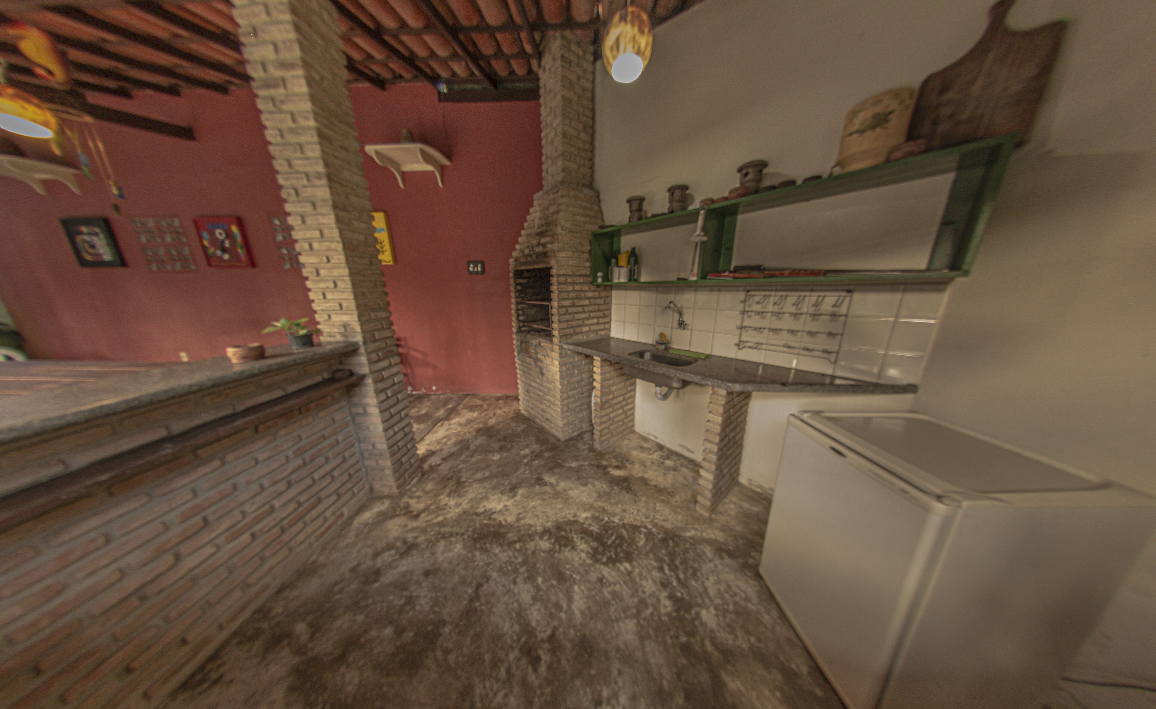 A kitchen with a brick oven, a sink, and a refrigerator.