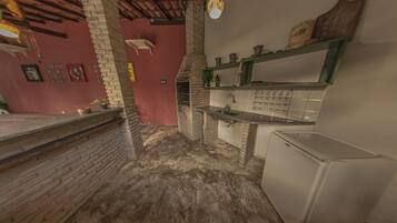 A kitchen with a brick oven, a sink, and a refrigerator.