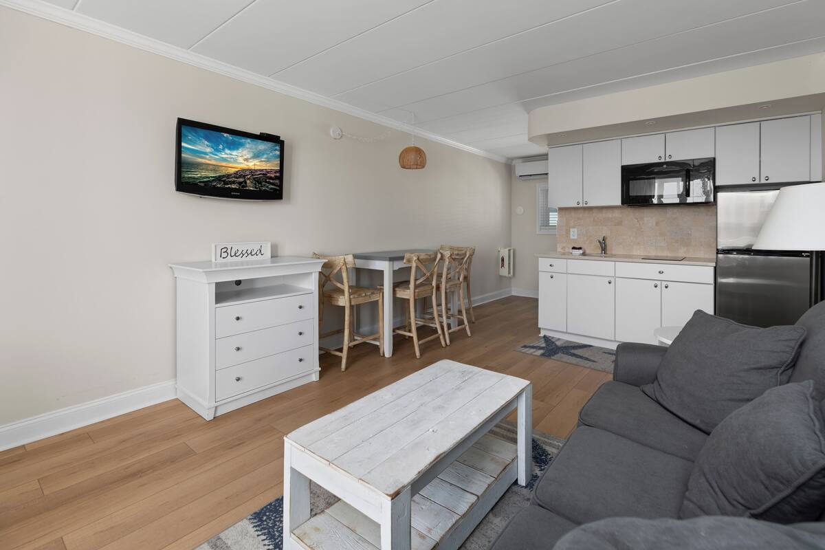 A modern kitchen with white cabinets, a built-in microwave, and a stainless steel refrigerator.
